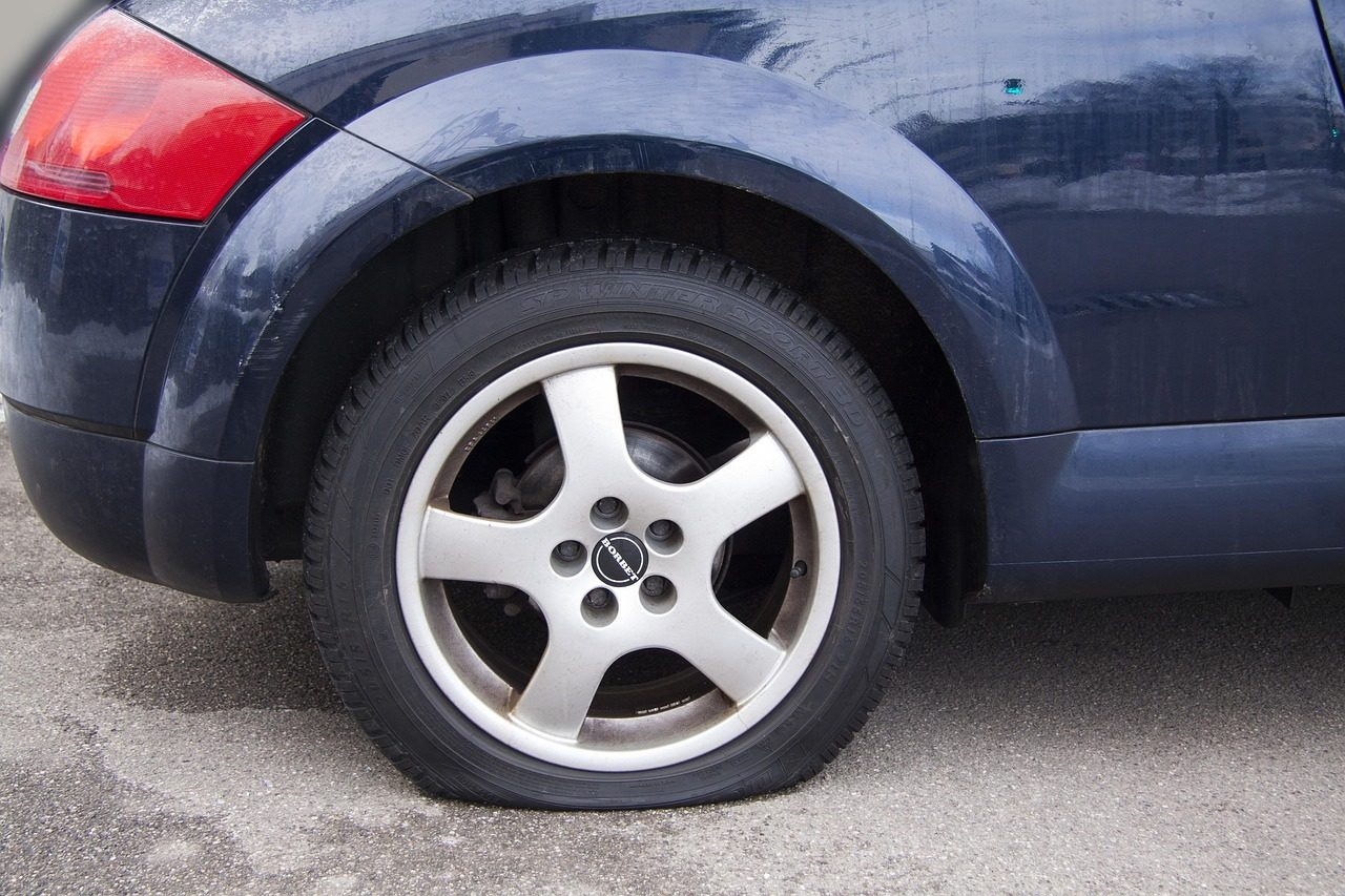 Flat tire with sidewall damage on a parked car